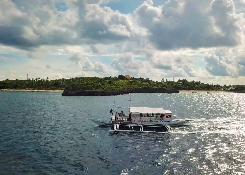 Aerial drone view of Malapascua Island and dive boat